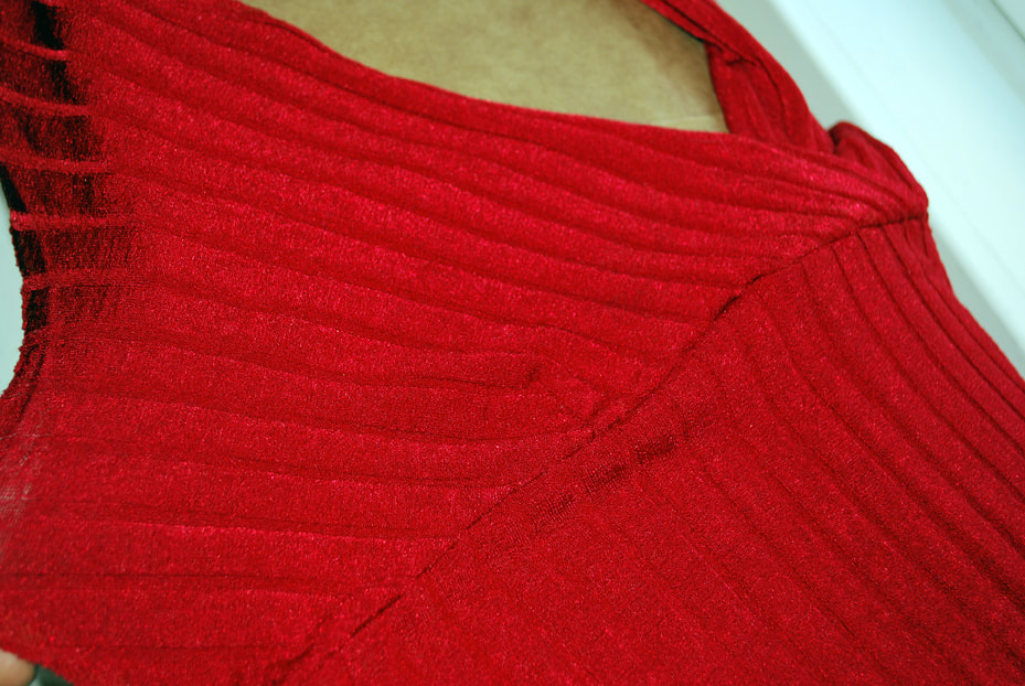 Two bust panels of a red knit top. The fabric is a textured, regular red stripe.