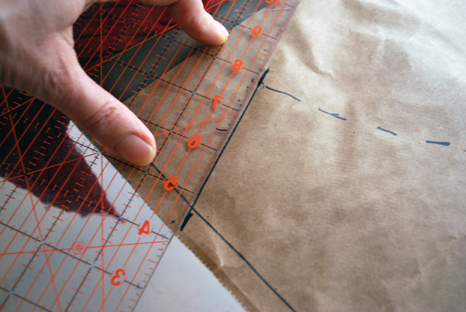 Lining up a ruler with cross marks on the pattern paper.