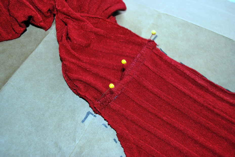 A well-pinned shoulder seam on the red top.