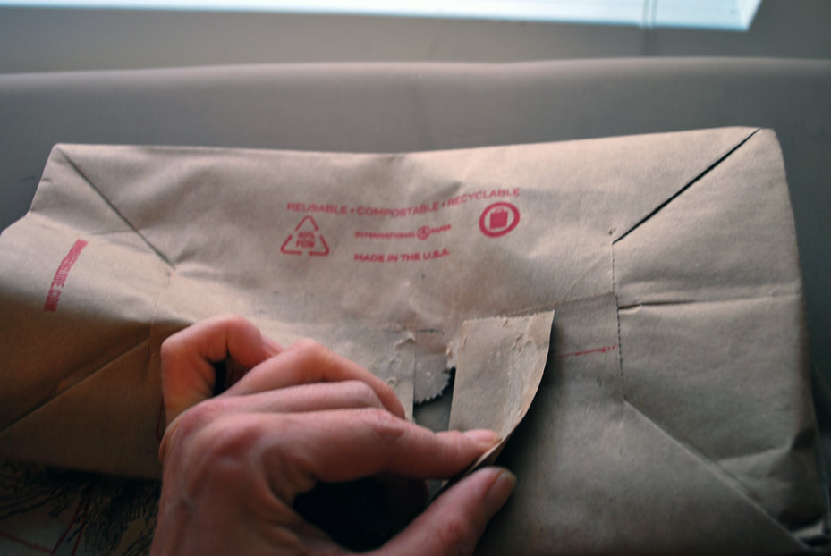Peeling the paper bag's seam apart and reaching the bag bottom
