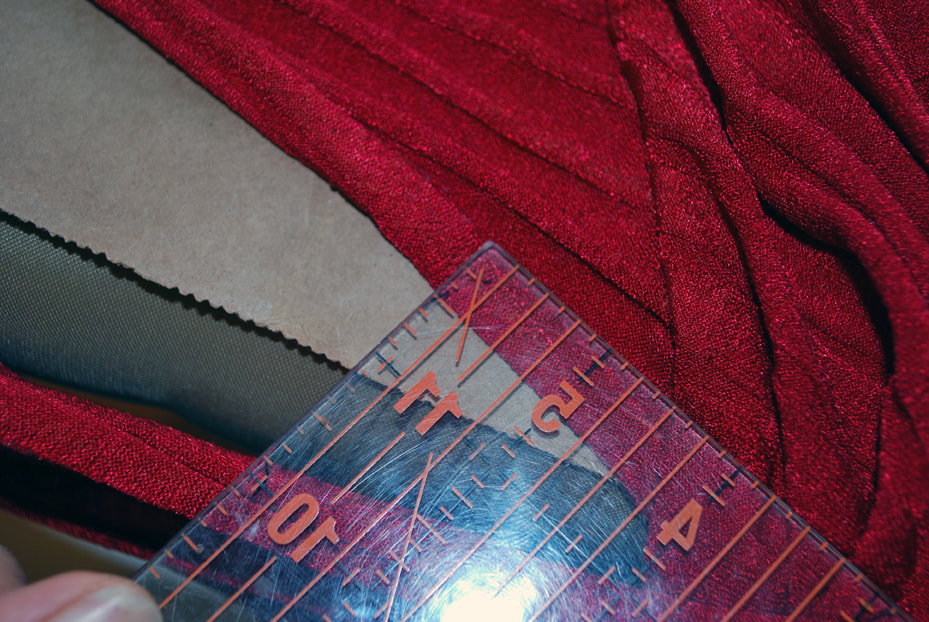 A ruler measures the folded back seam allowance on the top of the bust panel.