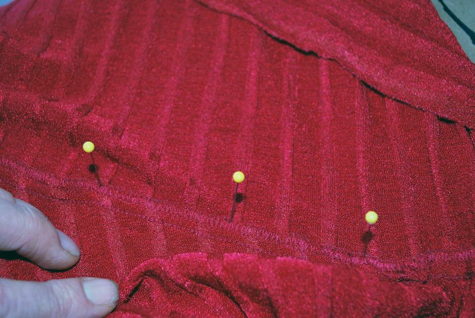 Pinning the outside of the under bust seam allowances to mark the line.