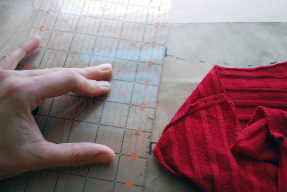 Lining up a ruler to the shoulder seam cross marks.