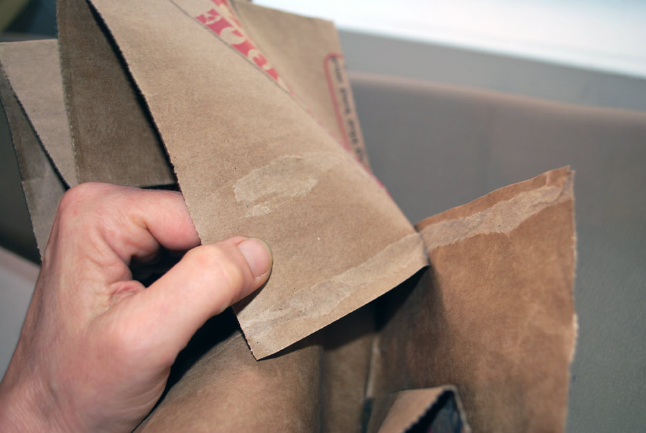 Peeling apart a paper bag along its glued seam