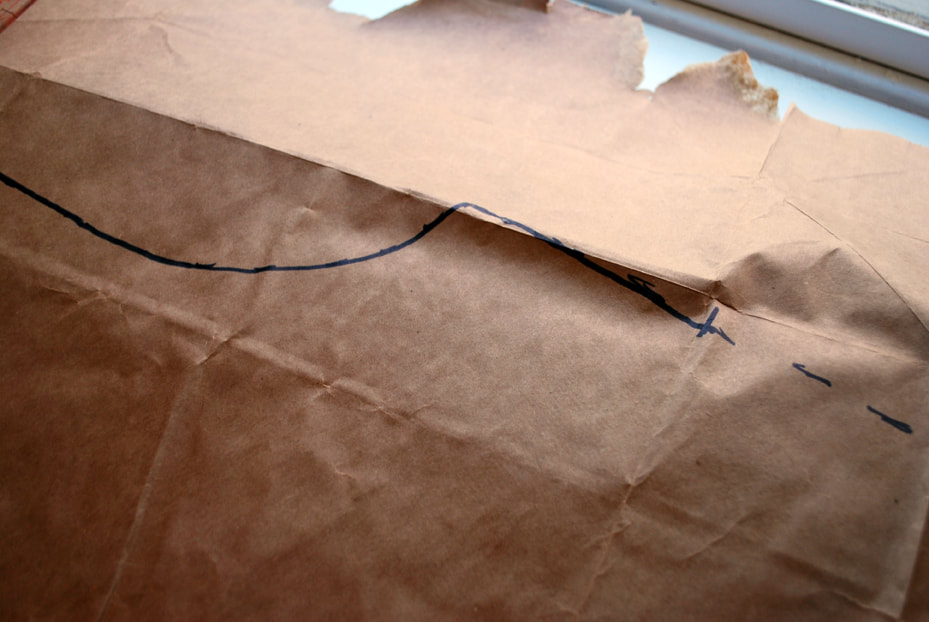 A smooth armhole curve is drawn by following the dots on the paper. This line connects to the pattern's side seam.