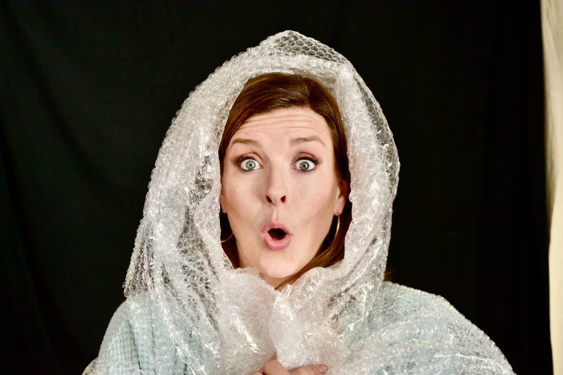 A surprised looking pale skinned woman with a hood made of bubble wrap