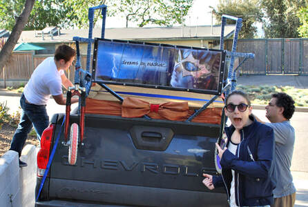 Three people load a cart with a banner reading 